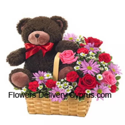 Un magnifique panier composé de roses rouges et roses, de œillets rouges et d'autres fleurs assorties de couleur violette accompagné d'un mignon ourson de 14 pouces de hauteur