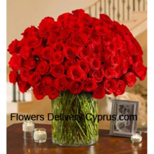 100 Red Roses With Some Ferns In A Big Glass Vase