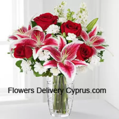 Roses rouges, lys roses avec des fleurs blanches assorties dans un vase en verre
