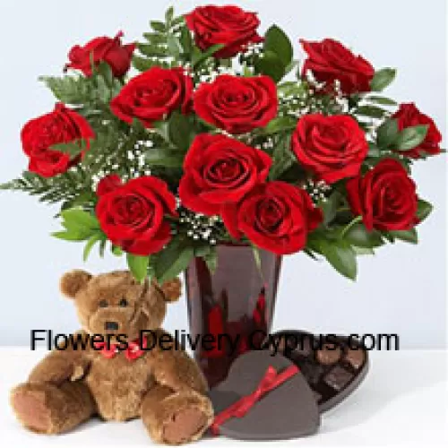 12 Red Roses With Some Ferns In A Vase, Cute Brown 10 Inches Teddy Bear And A Heart Shaped Chocolate Box.