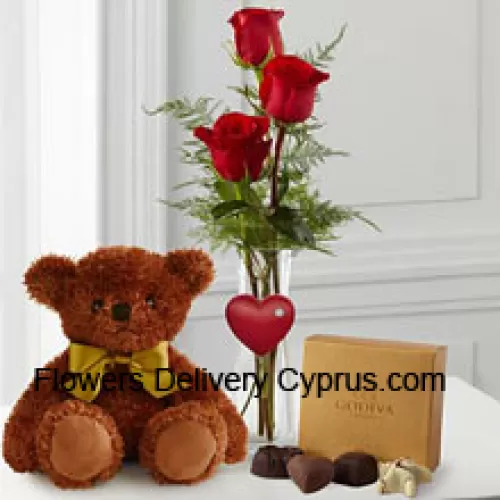Trois roses rouges avec des fougères dans un vase, un mignon ours en peluche brun de 10 pouces et une boîte de chocolats Godiva. (Nous nous réservons le droit de remplacer les chocolats Godiva par des chocolats de valeur égale en cas de non disponibilité. Stock limité)
